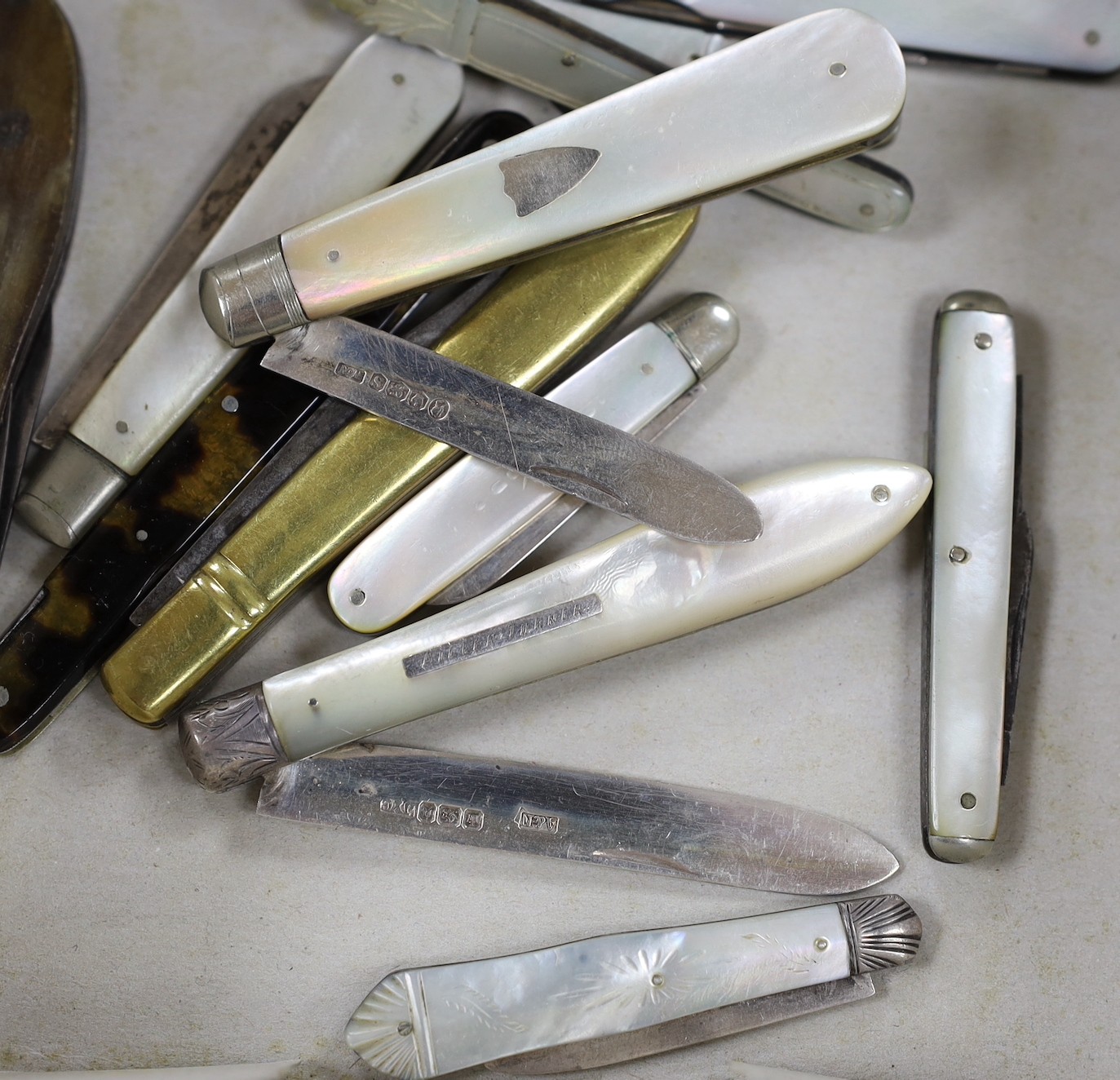 Five silver bladed mother of pearl fruit knives and seven various folding pocket knives (12)